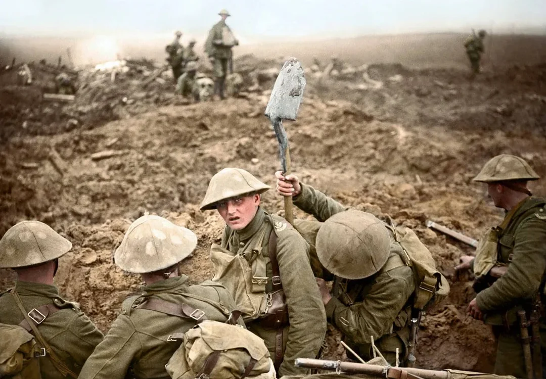 Several World War I soldiers in muddy trenches, wearing helmets and uniforms; one holds a spade upright. The background shows barren, war-torn land with more soldiers and debris under a cloudy sky.