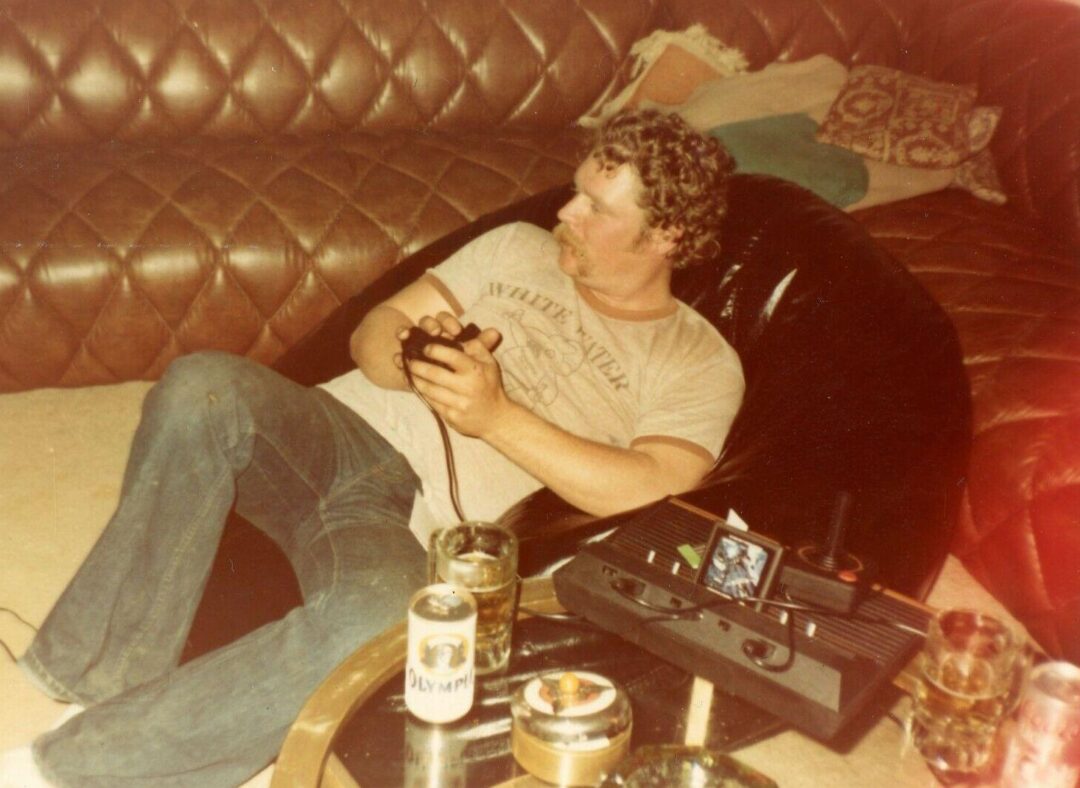 A man lying on a couch holding a game controller
