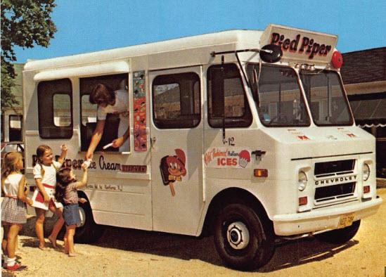 An ice cream truck labeled “Pied Piper” serves treats to a group of children waiting in line; a man hands ice cream to a girl at the window on a sunny day.