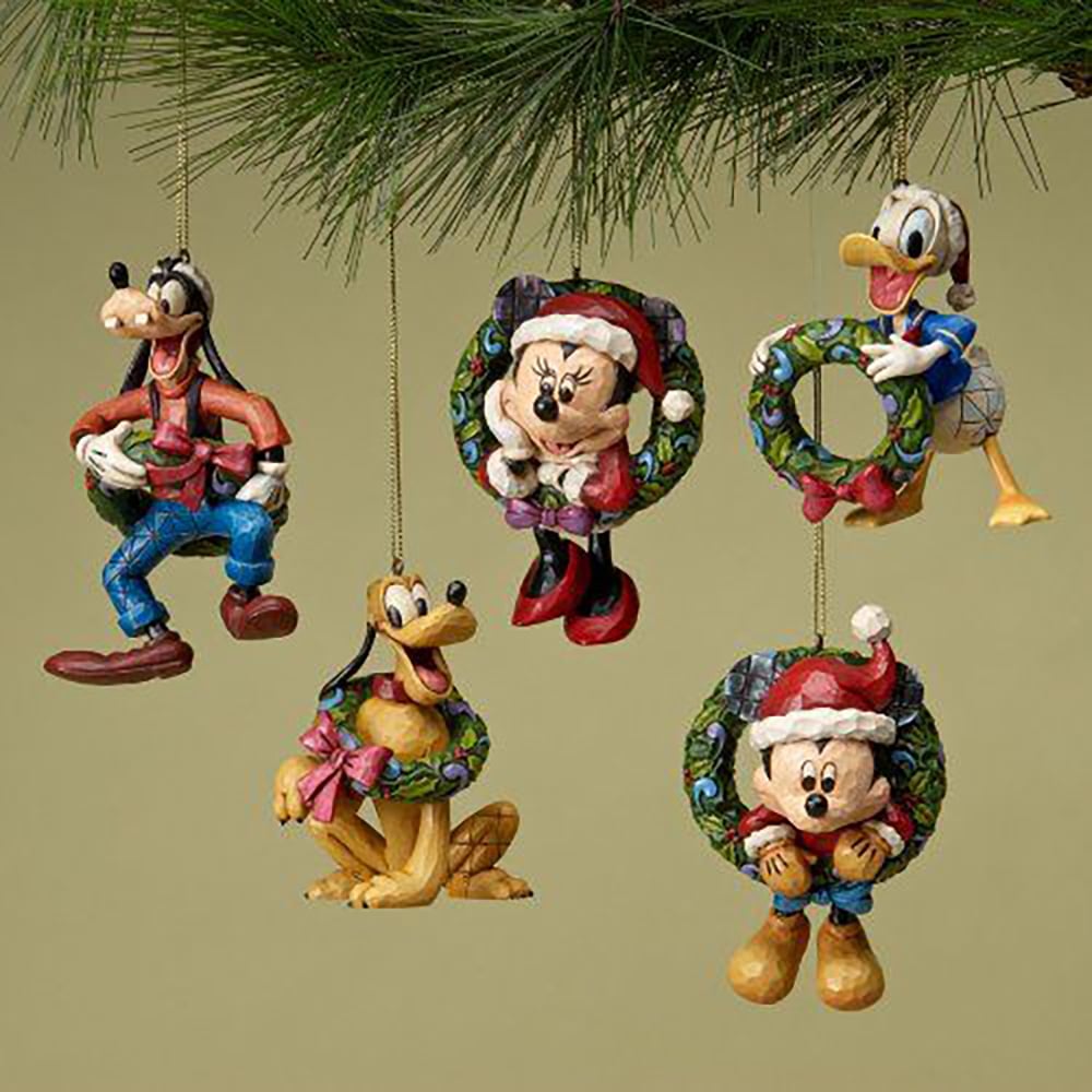 Five Christmas ornaments featuring Disney characters—Goofy, Minnie Mouse, Donald Duck, Pluto, and Mickey Mouse—hang from a pine branch. Each character is decorated with festive holiday attire and wreaths.