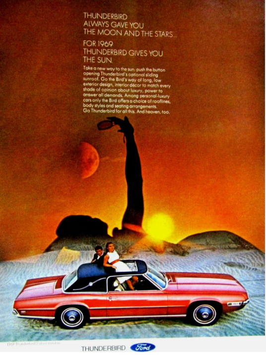 A couple sits in a red 1969 Ford Thunderbird convertible with the top down at sunset; in the background, a tall, shadowy statue of a woman holding a torch stands against an orange sky. Ford Thunderbird logo at bottom.