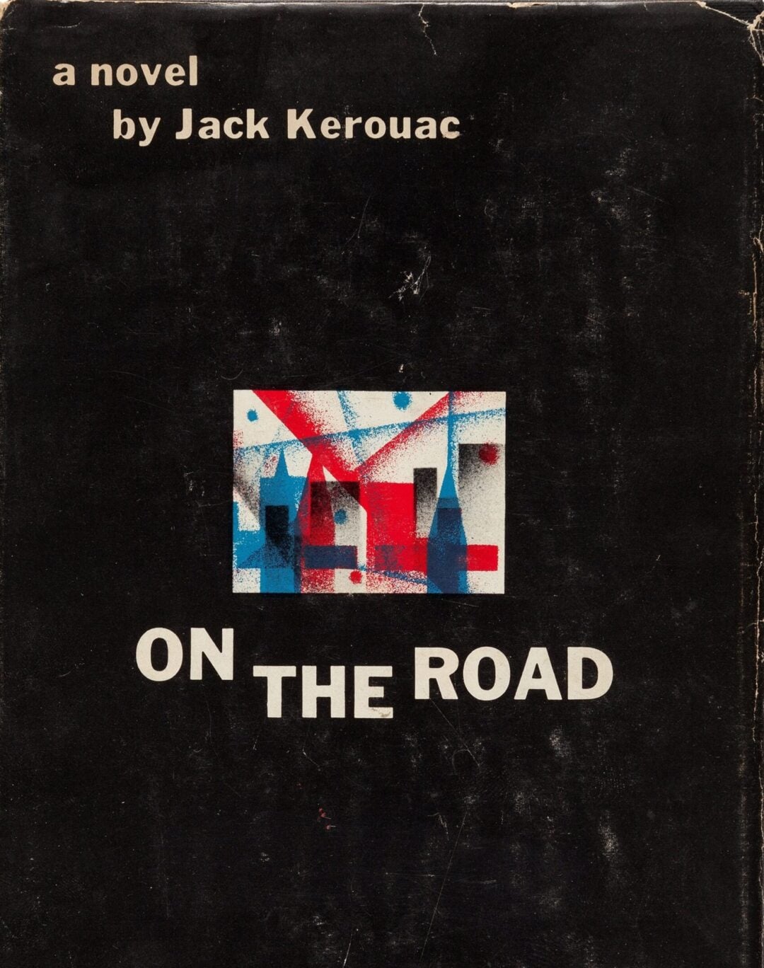 Book cover for "On the Road" by Jack Kerouac, featuring a small abstract red and blue illustration of buildings on a black background with the title in large white letters below the image.