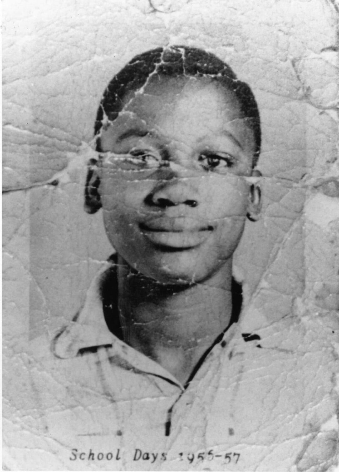 A black and white, worn and creased portrait photo of a young boy in a collared shirt. The text at the bottom reads "School Days 1955-57.