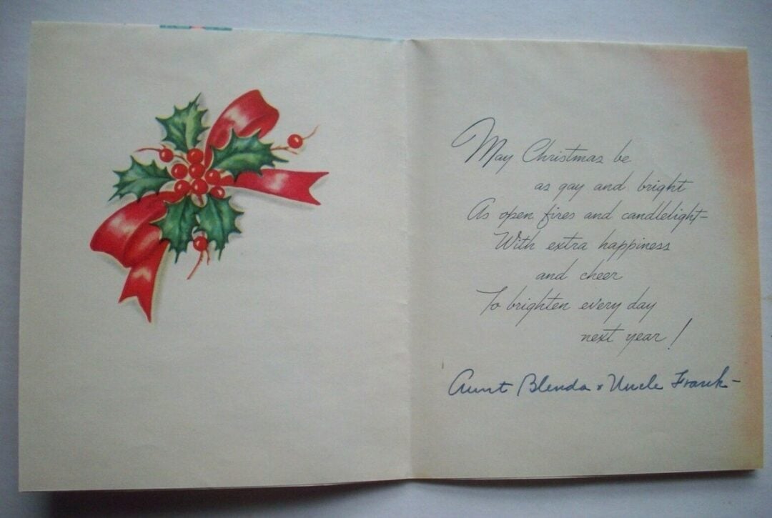 An open Christmas card featuring a sprig of holly with red berries and a red ribbon on the left, and a handwritten holiday message signed “Aunt Blenda + Uncle Frank” on the right.