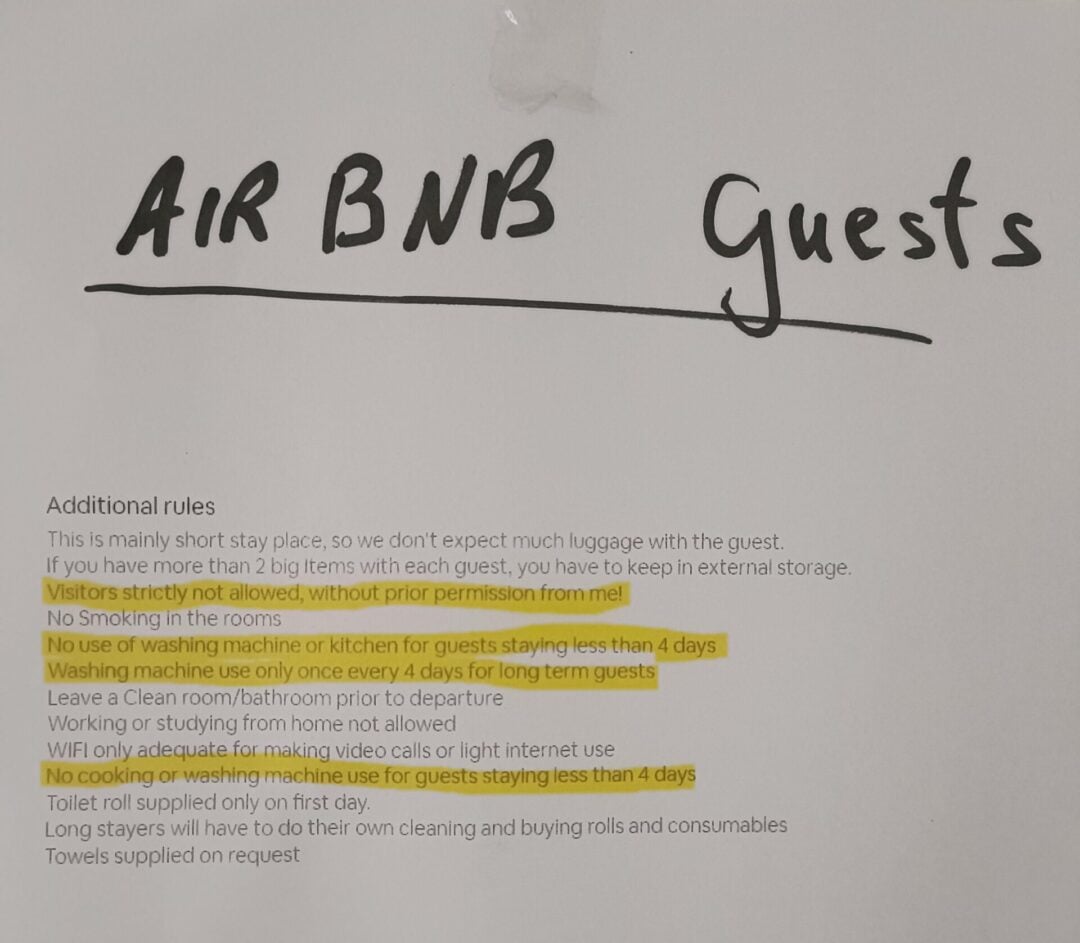 A printed notice titled "AIR BNB Guests" lists house rules, including restrictions on smoking, visitors, and washing machine use, with some text highlighted in yellow for emphasis.