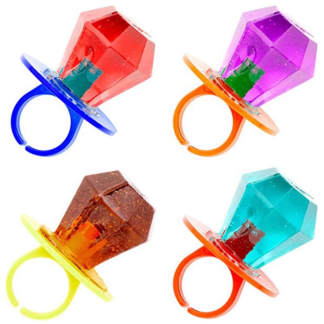Four colorful ring-shaped lollipops with large, gem-like candy tops in red, purple, orange, and blue, each with a matching plastic ring base.