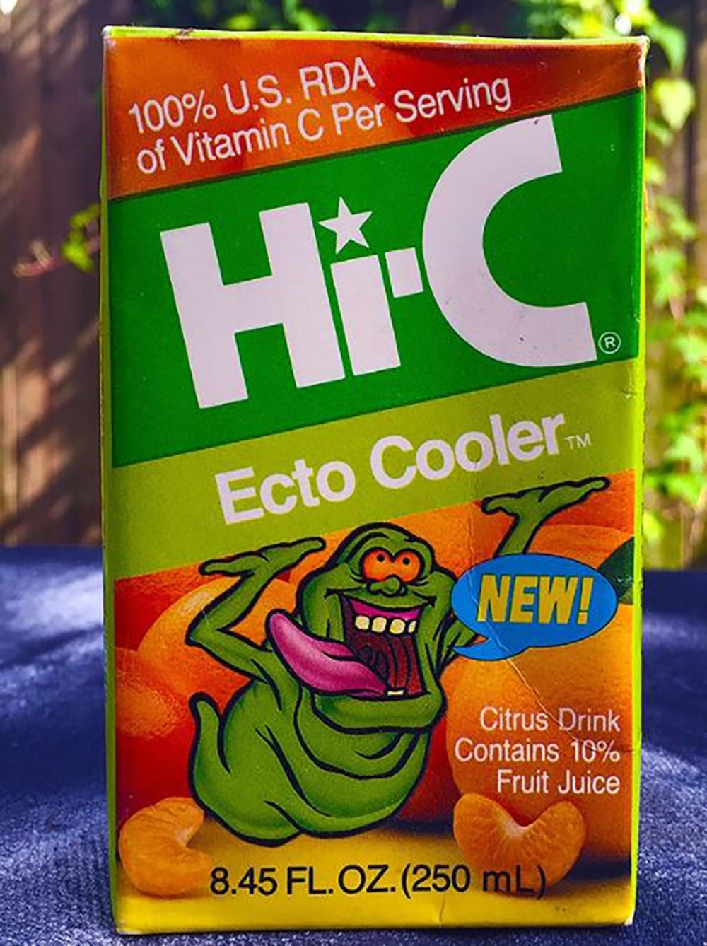 A Hi-C Ecto Cooler juice box featuring the green cartoon ghost Slimer from Ghostbusters, colorful text, and the label “100% U.S. RDA of Vitamin C Per Serving” with citrus drink information on the front.