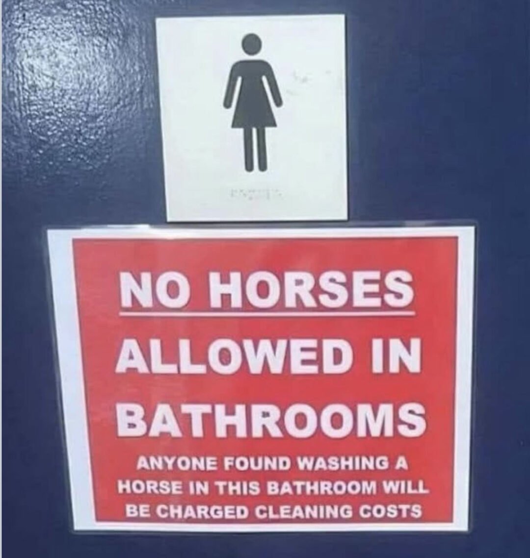 A women's restroom sign above a red notice that reads: "NO HORSES ALLOWED IN BATHROOMS. Anyone found washing a horse in this bathroom will be charged cleaning costs.