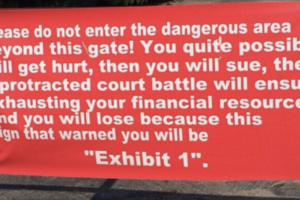 A red warning sign reads: "Please do not enter the dangerous area beyond this gate! You quite possibly will get hurt, then you will sue, then a protracted court battle will ensue... this sign that warned you will be 'Exhibit 1'.