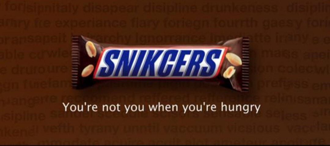 A scene from a movie shows a man lying down with his chest open as another person's hands reach inside. Below is a Snickers bar with the caption: "You're not you when you're hungry.