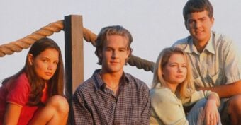 Four young adults sit and lean together outdoors by a wooden railing with thick rope, smiling slightly, in soft, warm sunlight.