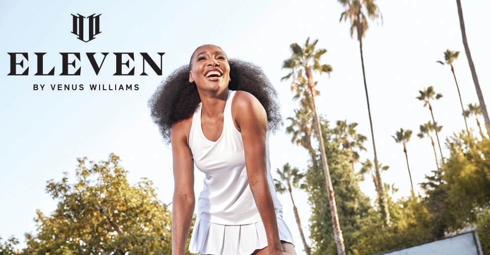 A smiling woman in a white tennis outfit leans forward on an outdoor court, surrounded by palm trees. The image features the logo and text: "ELEVEN by Venus Williams" and "DESIGNED BY VENUS, MADE TO PERFORM.