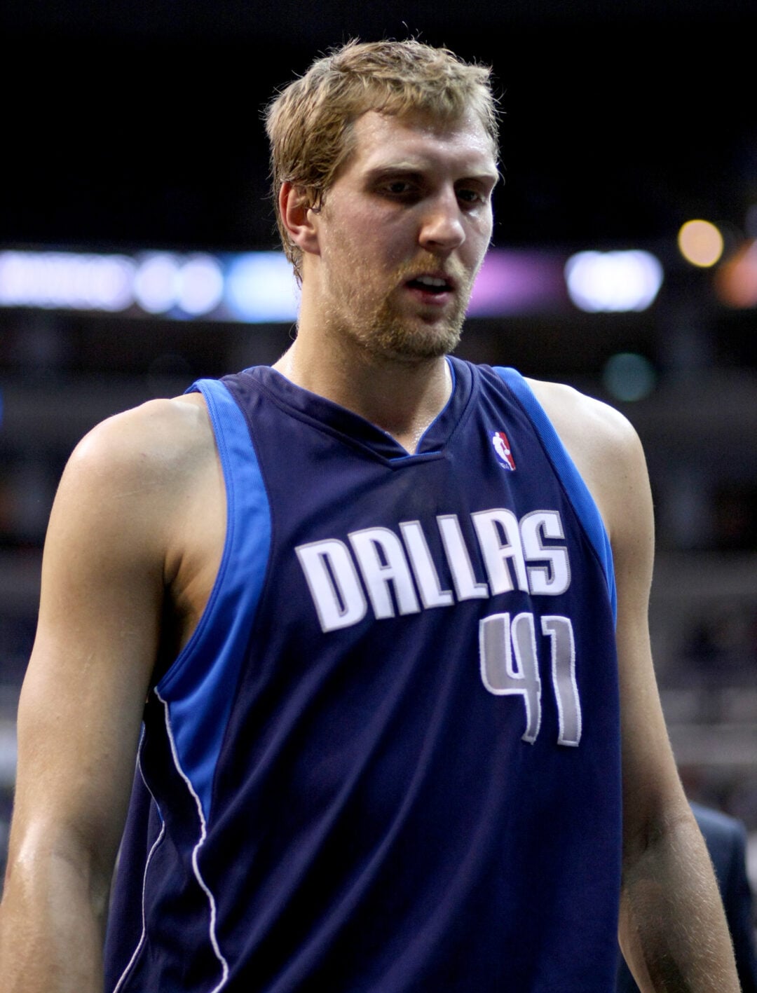 A basketball player wearing a dark blue Dallas Mavericks jersey with the number 41 stands on the court, appearing focused during a game.