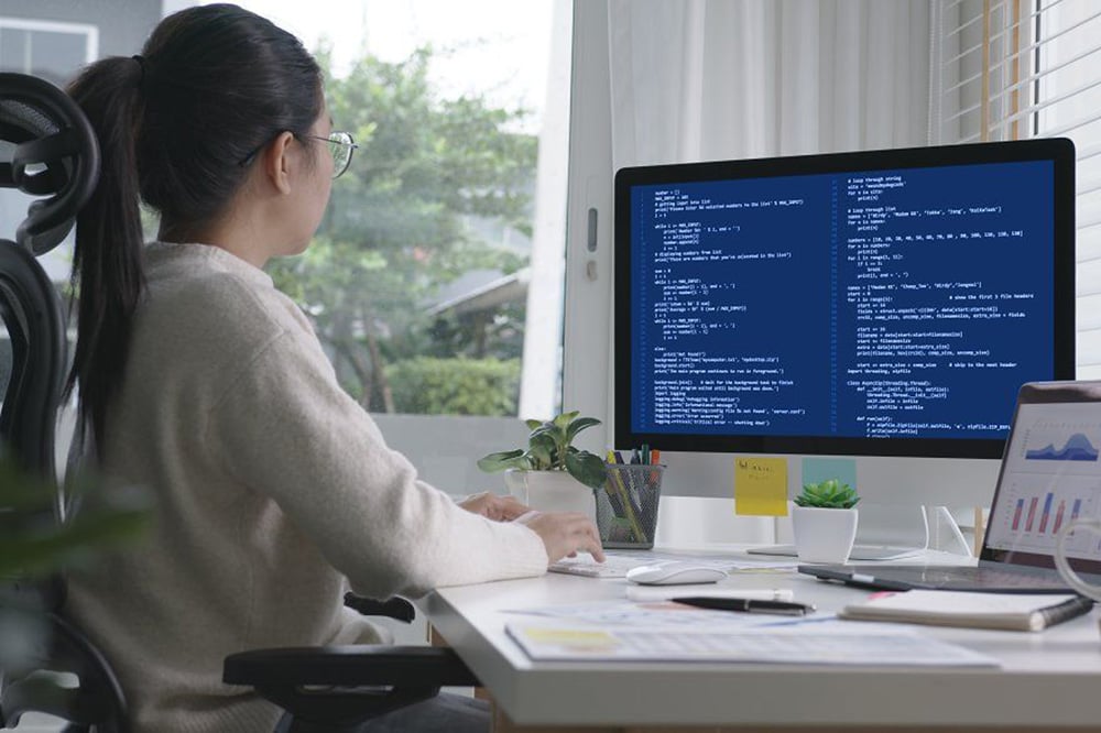 A woman sitting at a desk working on a computer