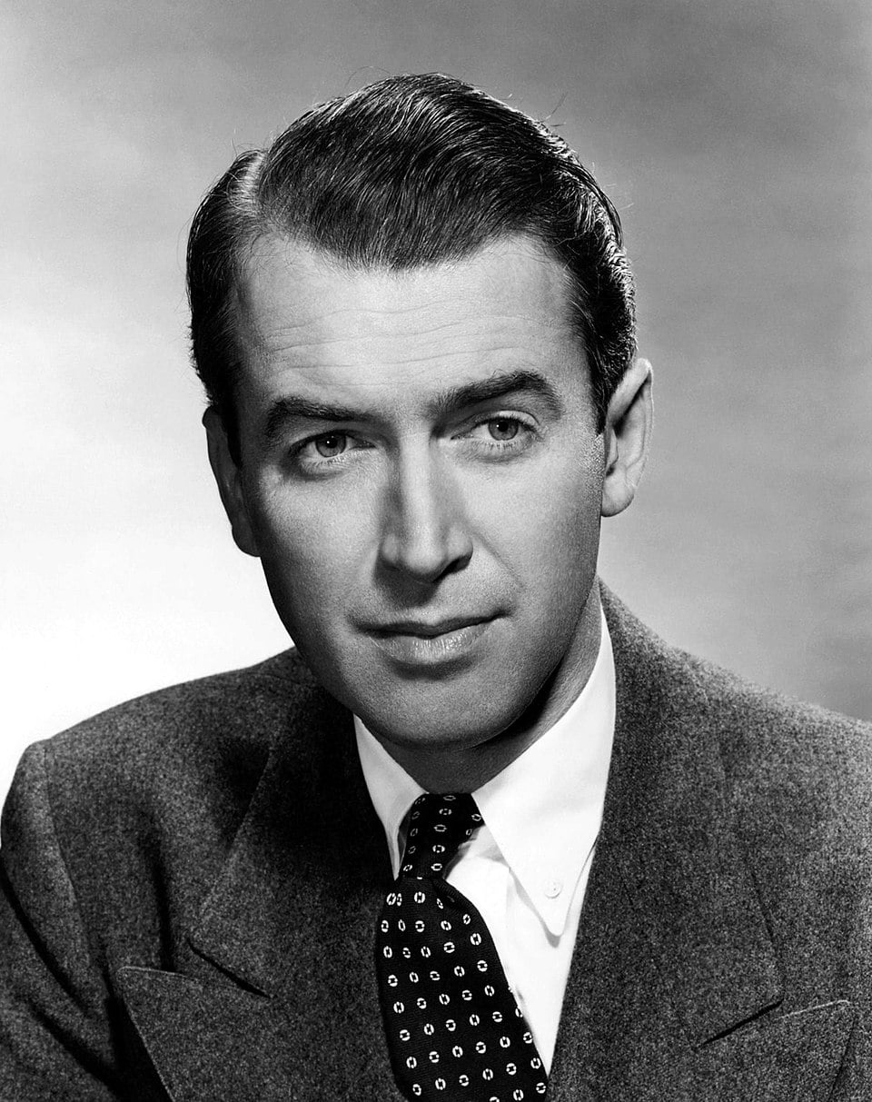 Black-and-white portrait of a man in a suit and polka dot tie, with neatly combed hair, looking slightly to the side against a plain background.