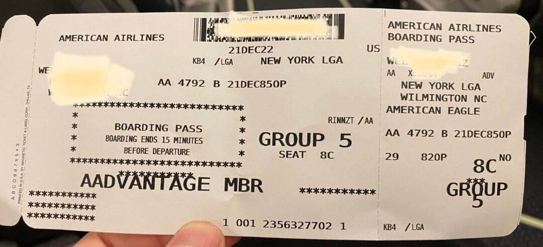 A hand holding a ticket