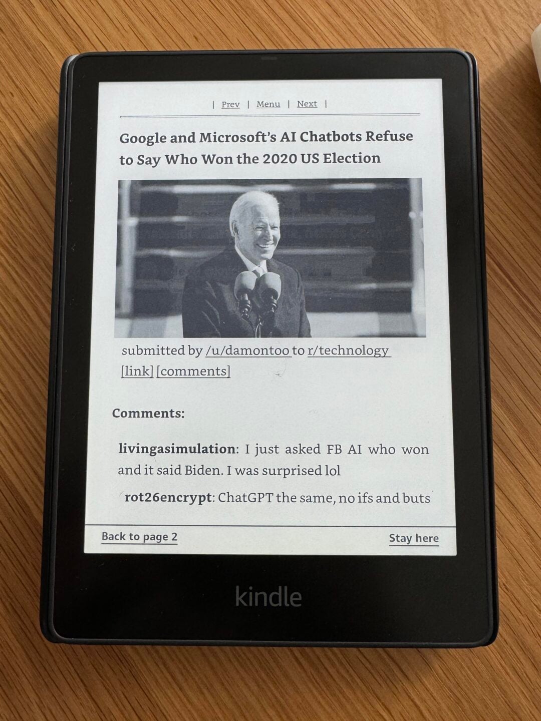 A Kindle displays a Reddit post titled "Google and Microsoft's AI Chatbots Refuse to Say Who Won the 2020 US Election," featuring a black-and-white photo of Joe Biden speaking at a podium.