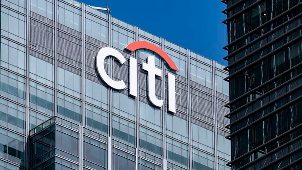 The Citi logo is displayed on the glass exterior of a modern office building against a clear blue sky.