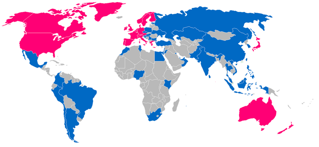 World map with countries colored pink, blue, or gray. North America, parts of Europe, and Australia are pink; most of Europe and Asia are blue; much of Africa and some parts of Asia and South America are gray. No labels shown.