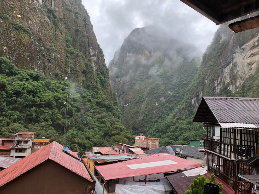 A group of buildings with trees and mountains in the background