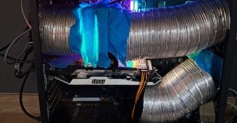 A computer case with large metal ventilation ducts attached, secured with blue tape, likely for custom cooling. The interior features glowing LED lights and visible MSI hardware components.