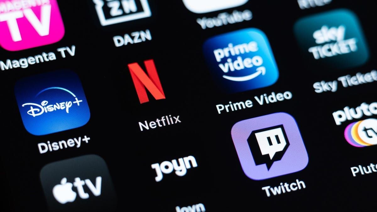 Close-up of a screen displaying various streaming app icons, including Disney+, Netflix, Prime Video, Apple TV, DAZN, Joyn, Twitch, Magenta TV, Sky Ticket, and Pluto TV, on a black background.