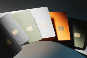 A fan of six credit cards in green, white, orange, and black hues, each featuring a gold chip, displayed on a dark gradient background.