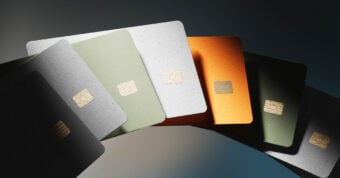 A fan of six credit cards in green, white, orange, and black hues, each featuring a gold chip, displayed on a dark gradient background.