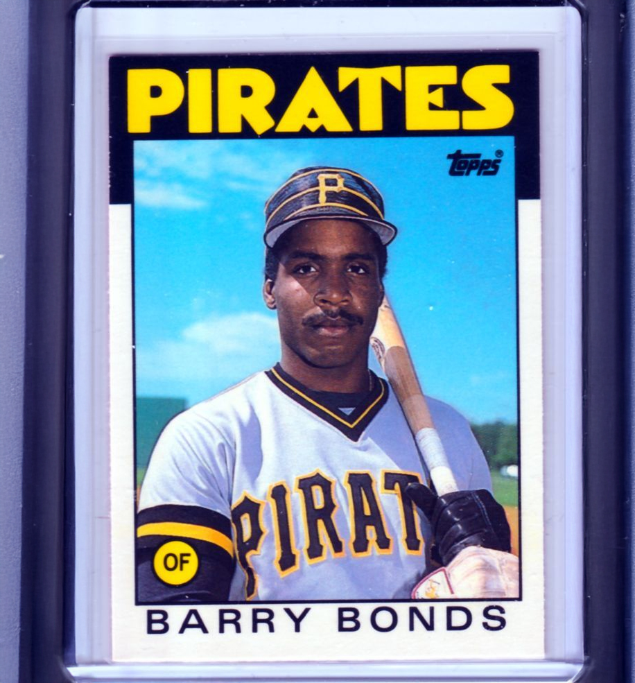 Baseball card featuring a player in a Pittsburgh Pirates uniform holding a bat, with “PIRATES,” “topps,” and “BARRY BONDS” written on the card. The player stands outdoors against a blue sky.