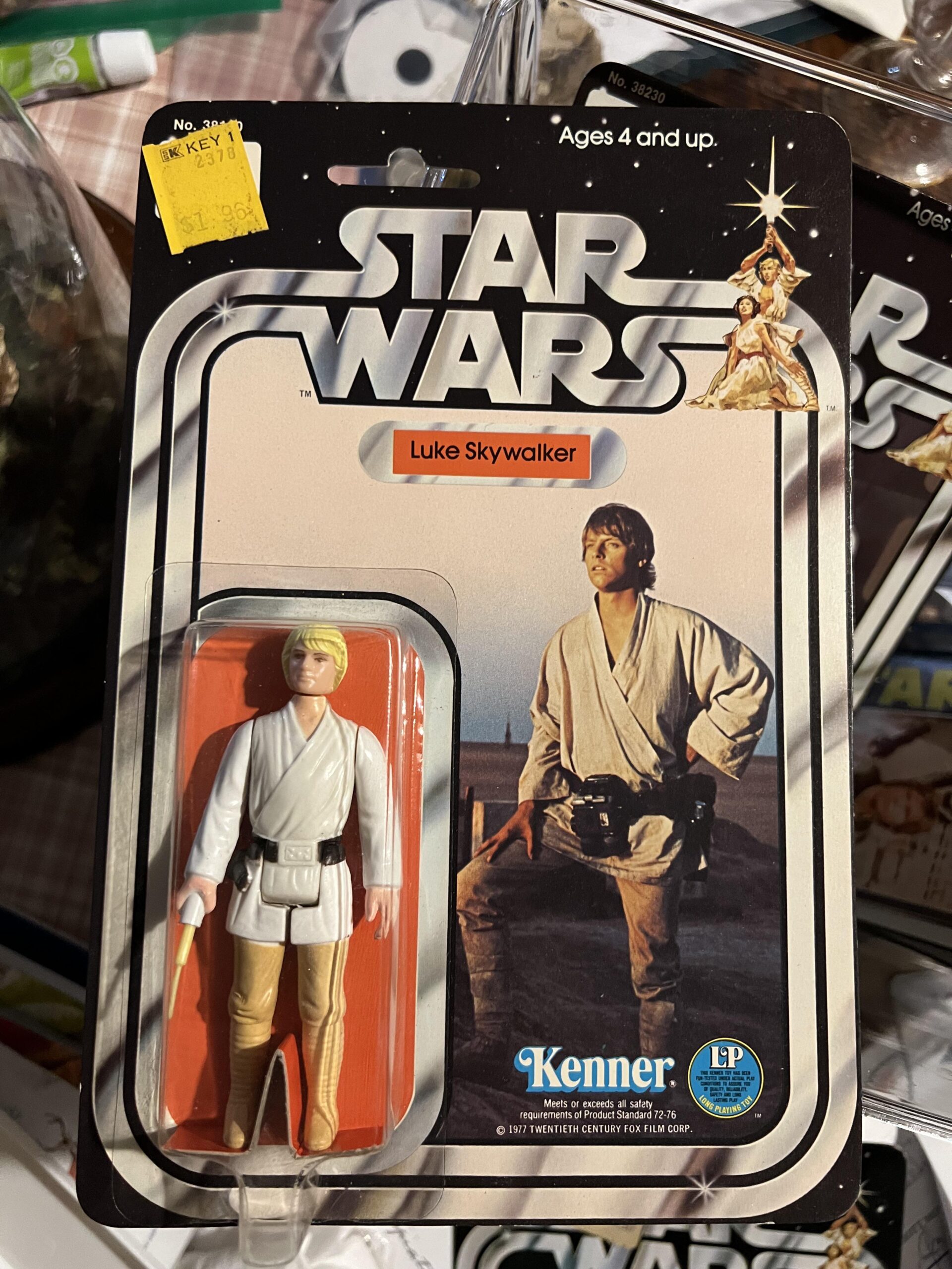 A vintage Star Wars Luke Skywalker action figure by Kenner, still in its original packaging, featuring an image of Luke on Tatooine, the Star Wars logo, and a yellow price sticker in the top left corner.