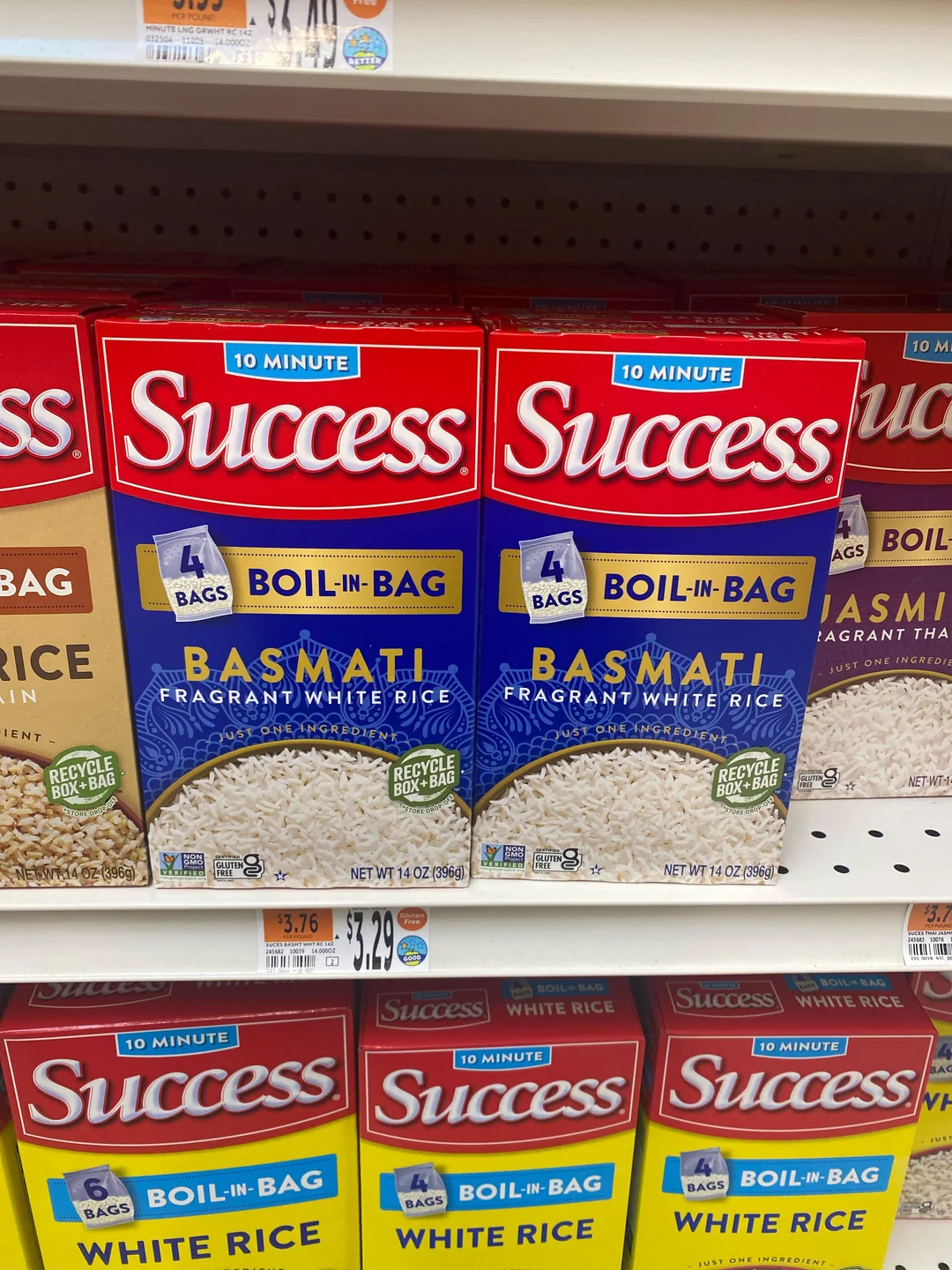Boxes of Success Boil-in-Bag Basmati white rice are displayed on a grocery store shelf, labeled as 10-minute cook time and containing four bags each. Price tags are visible below the products.