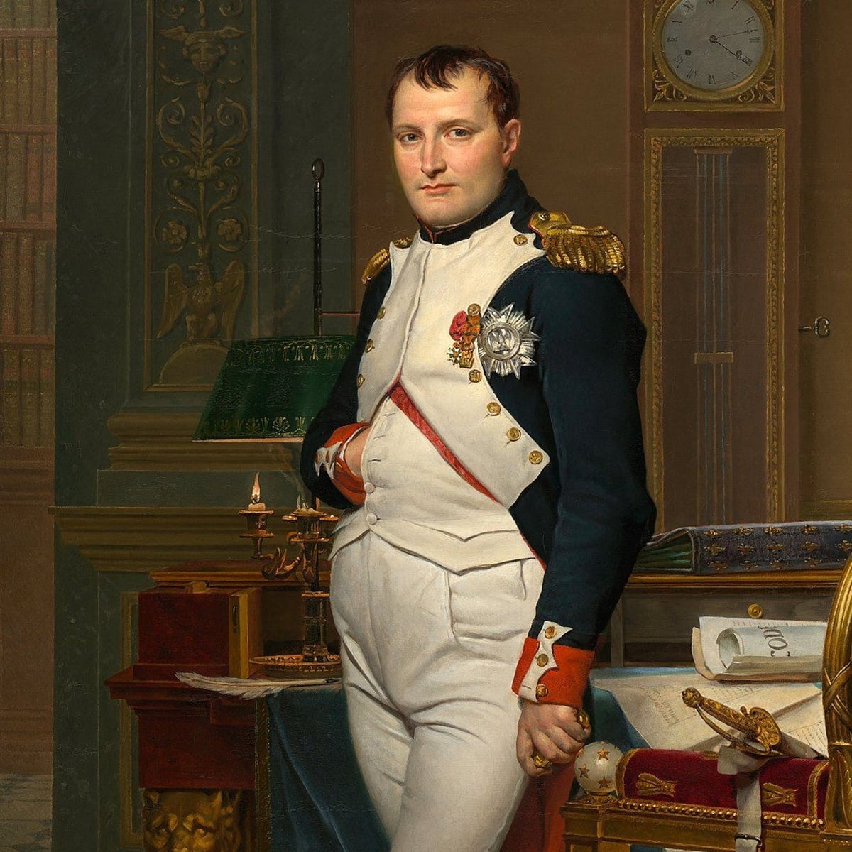 A man in a decorated military uniform stands with one hand in his vest, surrounded by books, papers, and a clock, in an ornate, scholarly room.