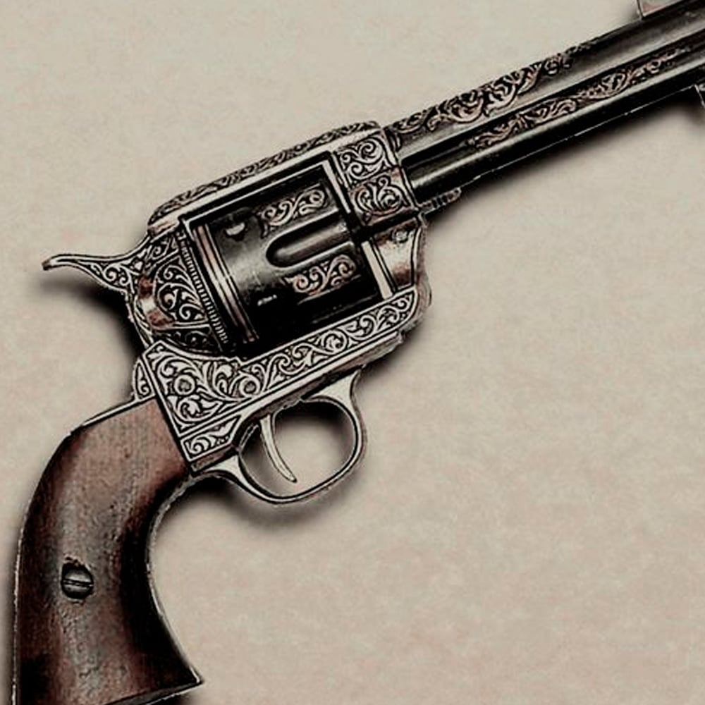 An ornately engraved vintage revolver with a wooden grip displayed on a neutral background.