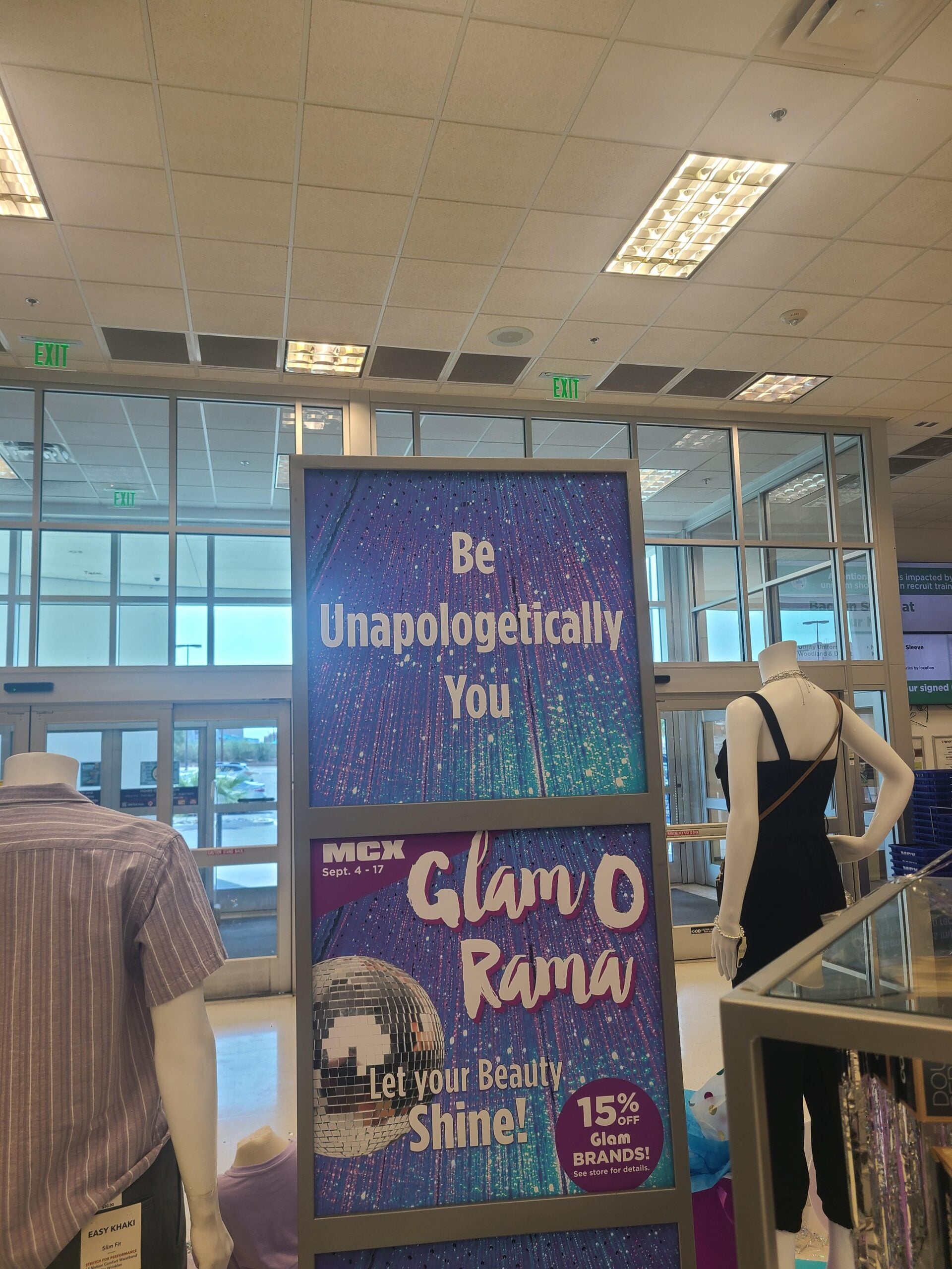 A store display sign reads "Be Unapologetically You" and "Glam O Rama, Let your Beauty Shine! 15% Off Glam Brands!" with mannequins and clothing racks visible in the background.