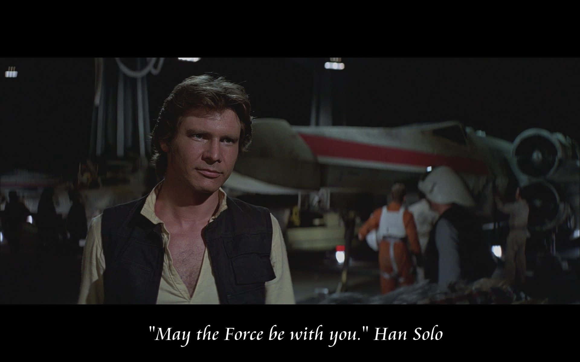 Han Solo stands in front of an X-wing starfighter at night, looking forward. Other pilots and crew are visible in the background. Text at the bottom reads, "May the Force be with you." Han Solo.