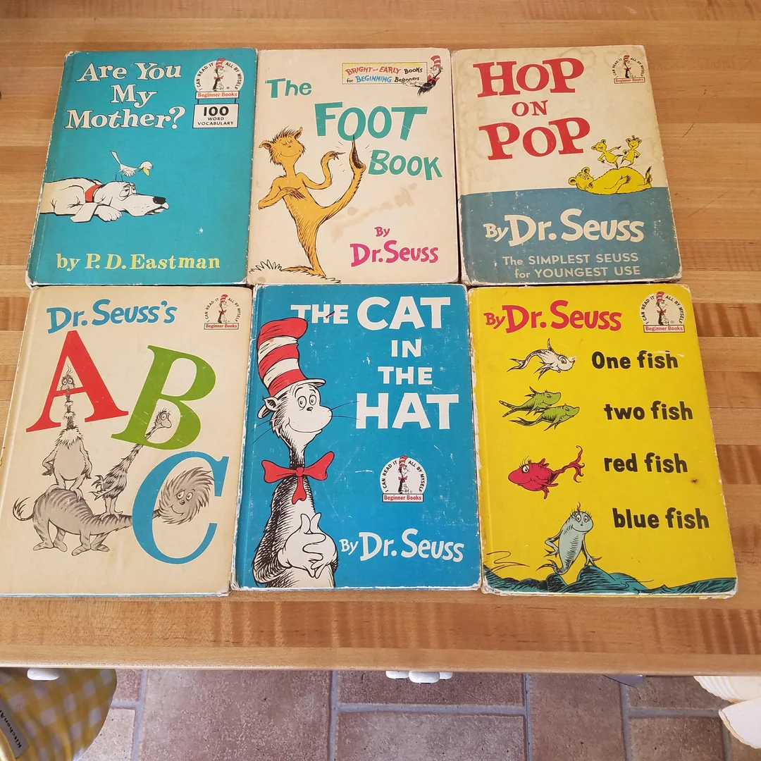 Six classic children's books are arranged on a wooden surface, including “Are You My Mother?”, “The Foot Book,” “Hop on Pop,” “Dr. Seuss’s ABC,” “The Cat in the Hat,” and “One Fish Two Fish Red Fish Blue Fish.”