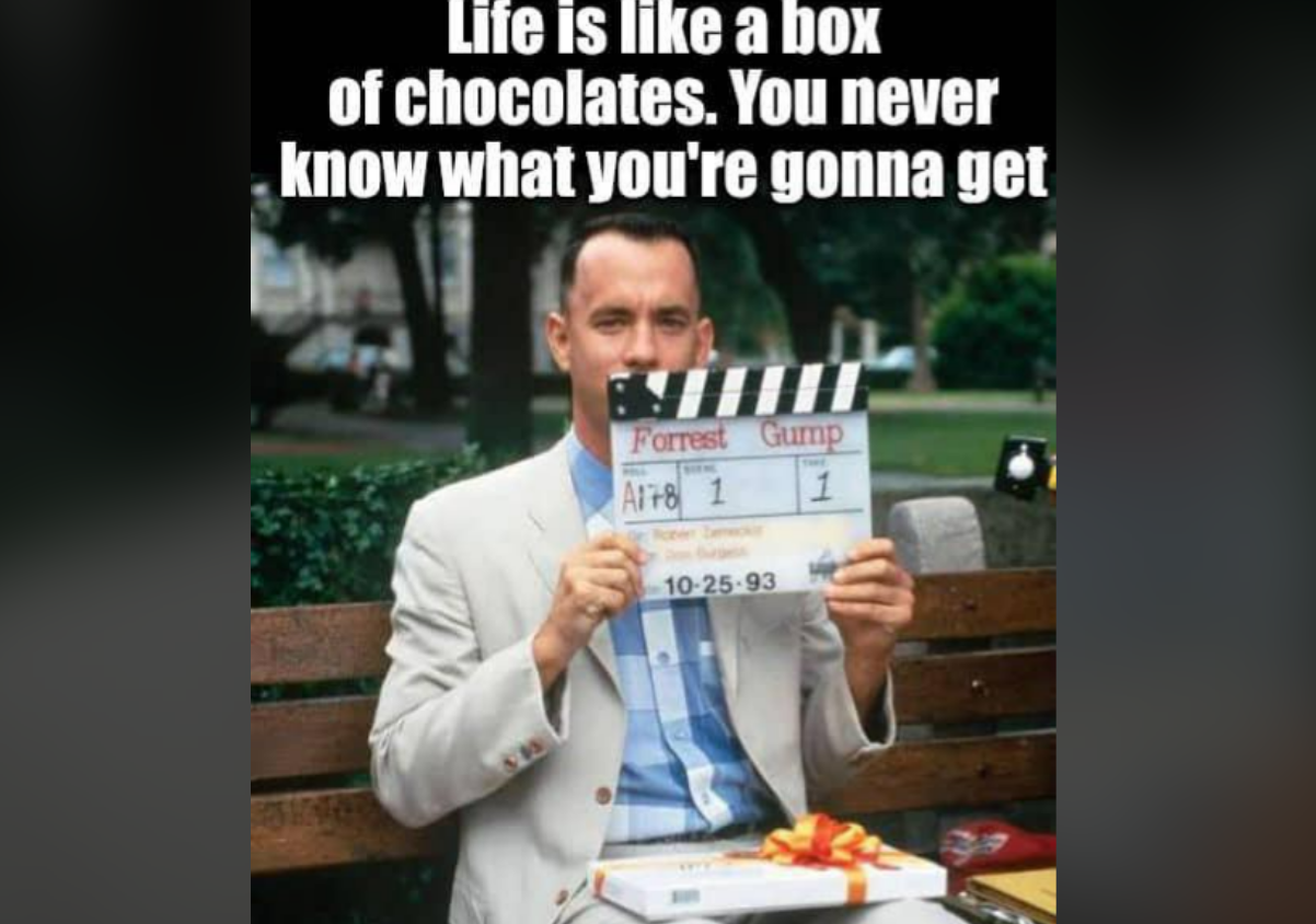A man in a beige suit sits on a bench holding a clapperboard labeled "Forrest Gump." Text above reads, "Life is like a box of chocolates. You never know what you're gonna get.