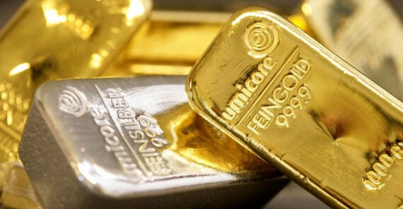 Close-up of gold and silver bars stacked together, with "umicore" and purity markings such as "FEINGOLD 999.9" and "FEINSILBER 999" engraved on the surfaces.