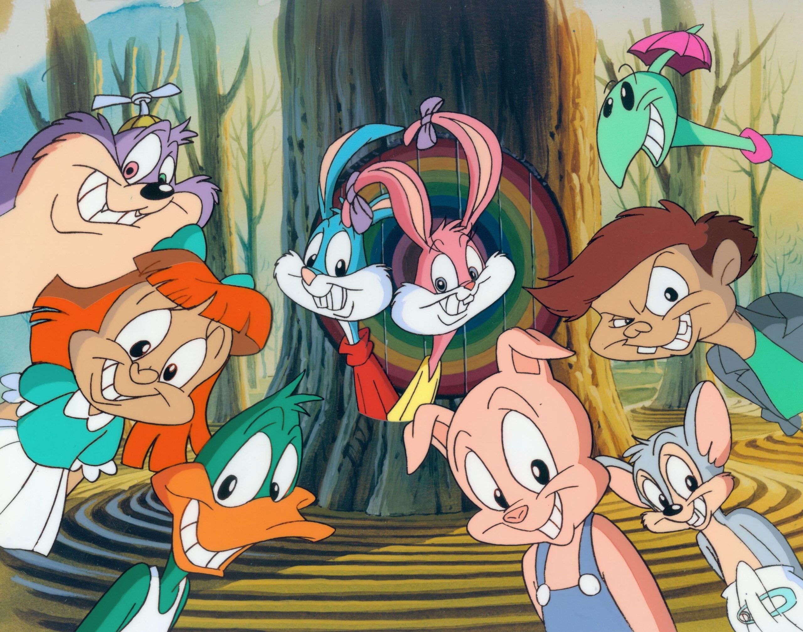 A group of animated animal characters, including a duck, pig, bunny, Tasmanian devil, mouse, and others, smile in front of a large tree with a colorful entrance in a forest setting.
