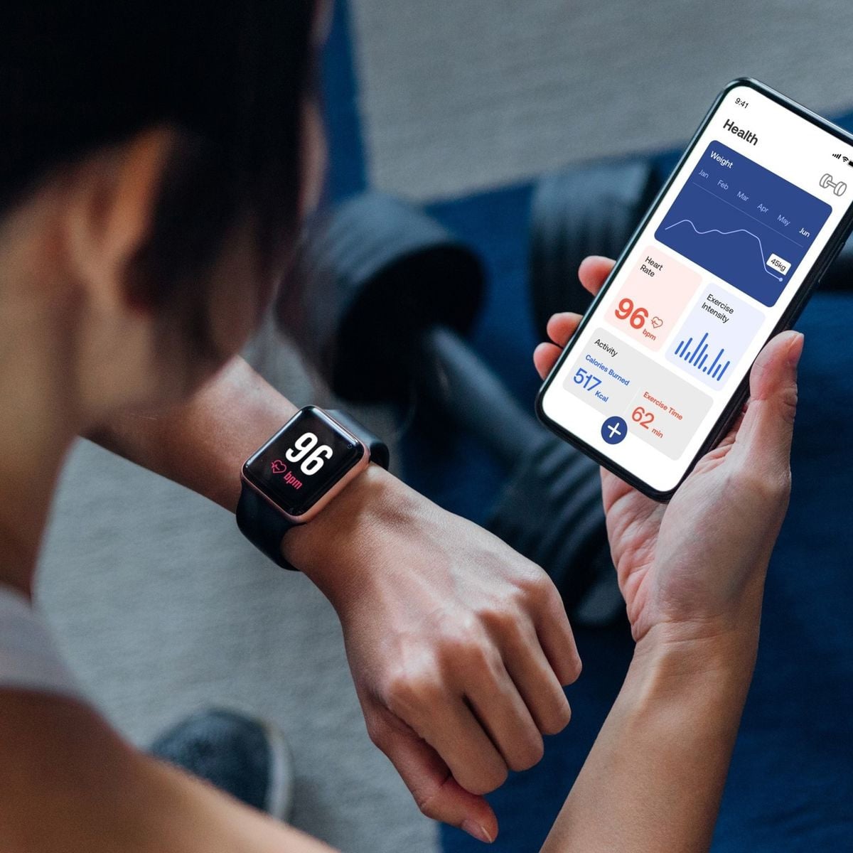 A person checks their smartwatch, which displays a heart rate of 96 bpm, while holding a smartphone showing health and fitness data. Dumbbells and a yoga mat are visible in the background.