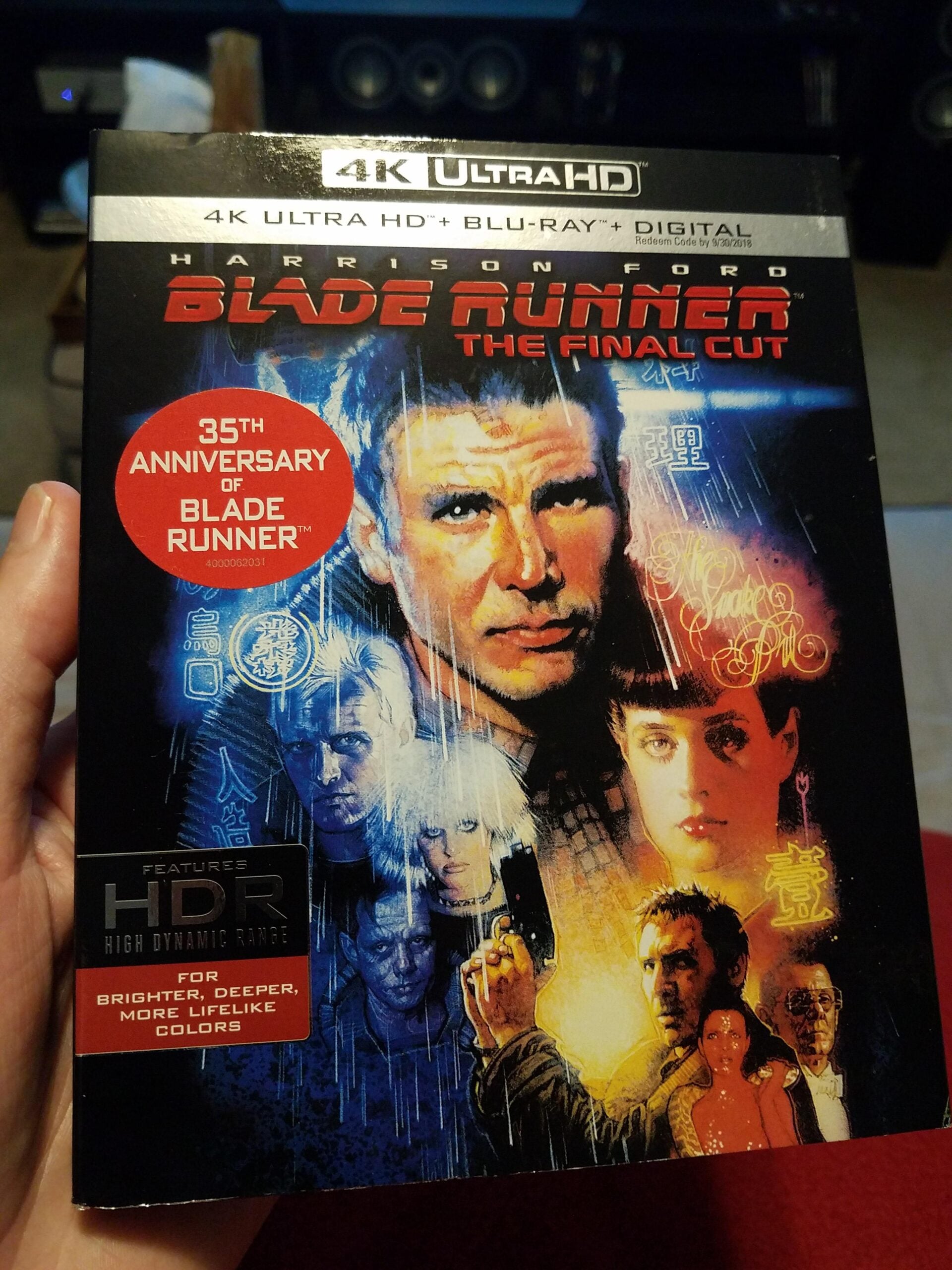 A hand holds a 4K Ultra HD Blu-ray box of "Blade Runner: The Final Cut," featuring Harrison Ford and other characters on the cover, with a red sticker noting the 35th anniversary of the film.