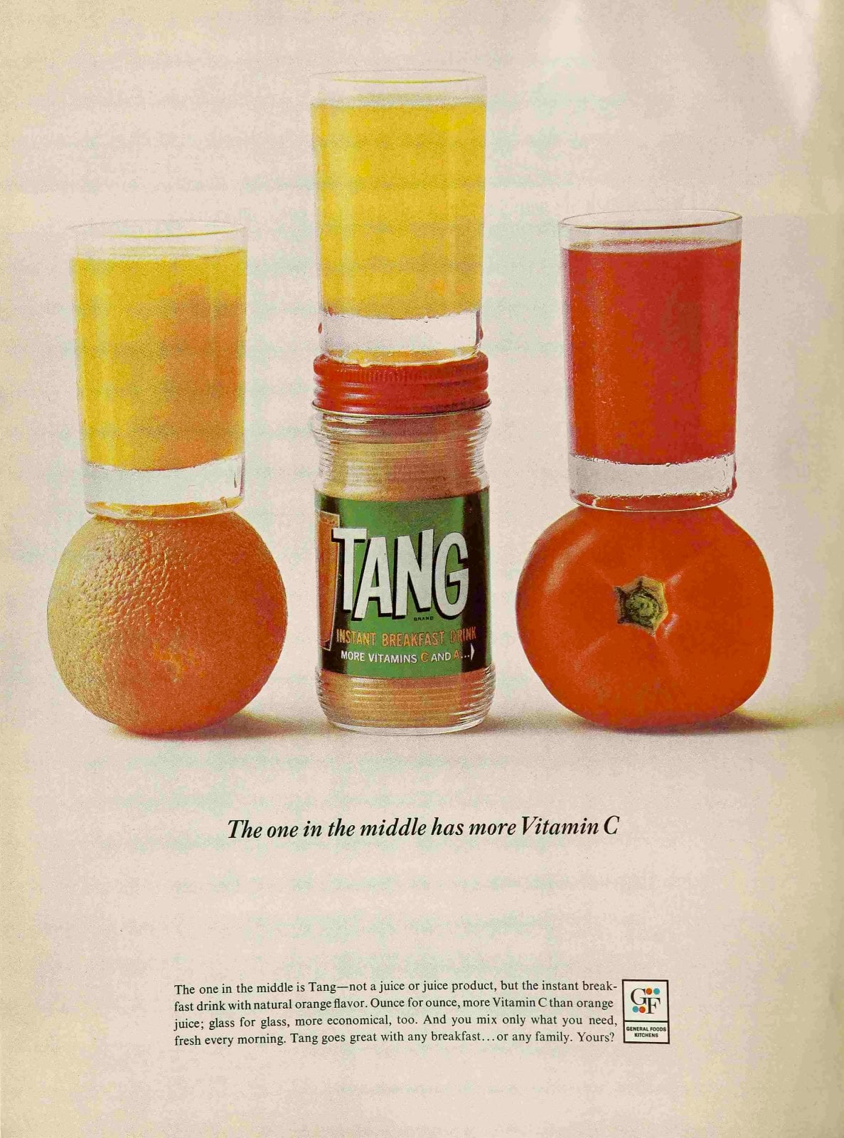 Three glasses with colored drinks are balanced atop an orange, a Tang jar, and a tomato. The glass on the Tang jar contains orange drink; the other glasses contain yellow and red drinks. Text promotes Tang's Vitamin C content.