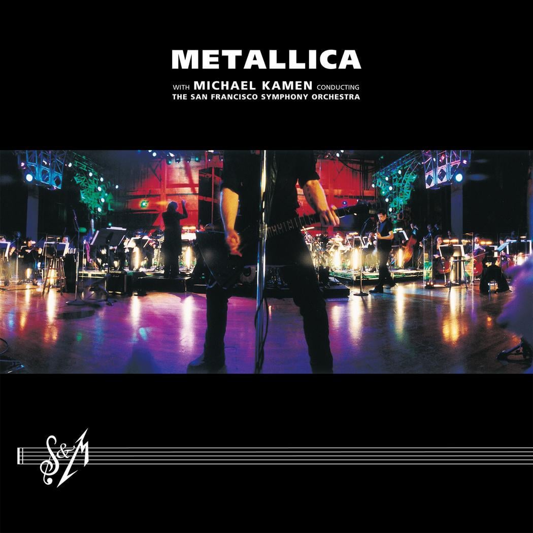 A stage lit with colorful lights shows Metallica performing with the San Francisco Symphony Orchestra. The band’s name is at the top, with Michael Kamen as conductor, and the S&M album logo is at the bottom.