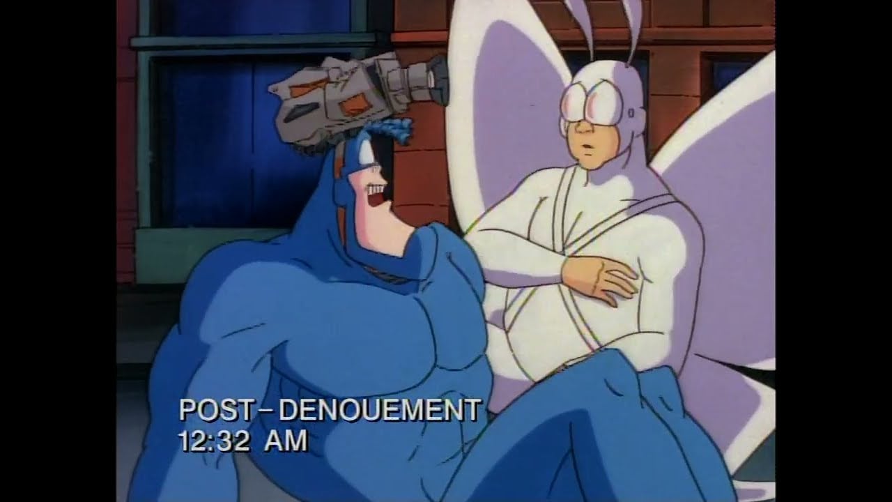 Two cartoon superheroes, one blue and muscular with a camera on his head, and one dressed as a white moth, sit together at night. On-screen text reads "POST-DENOUEMENT 12:32 AM.