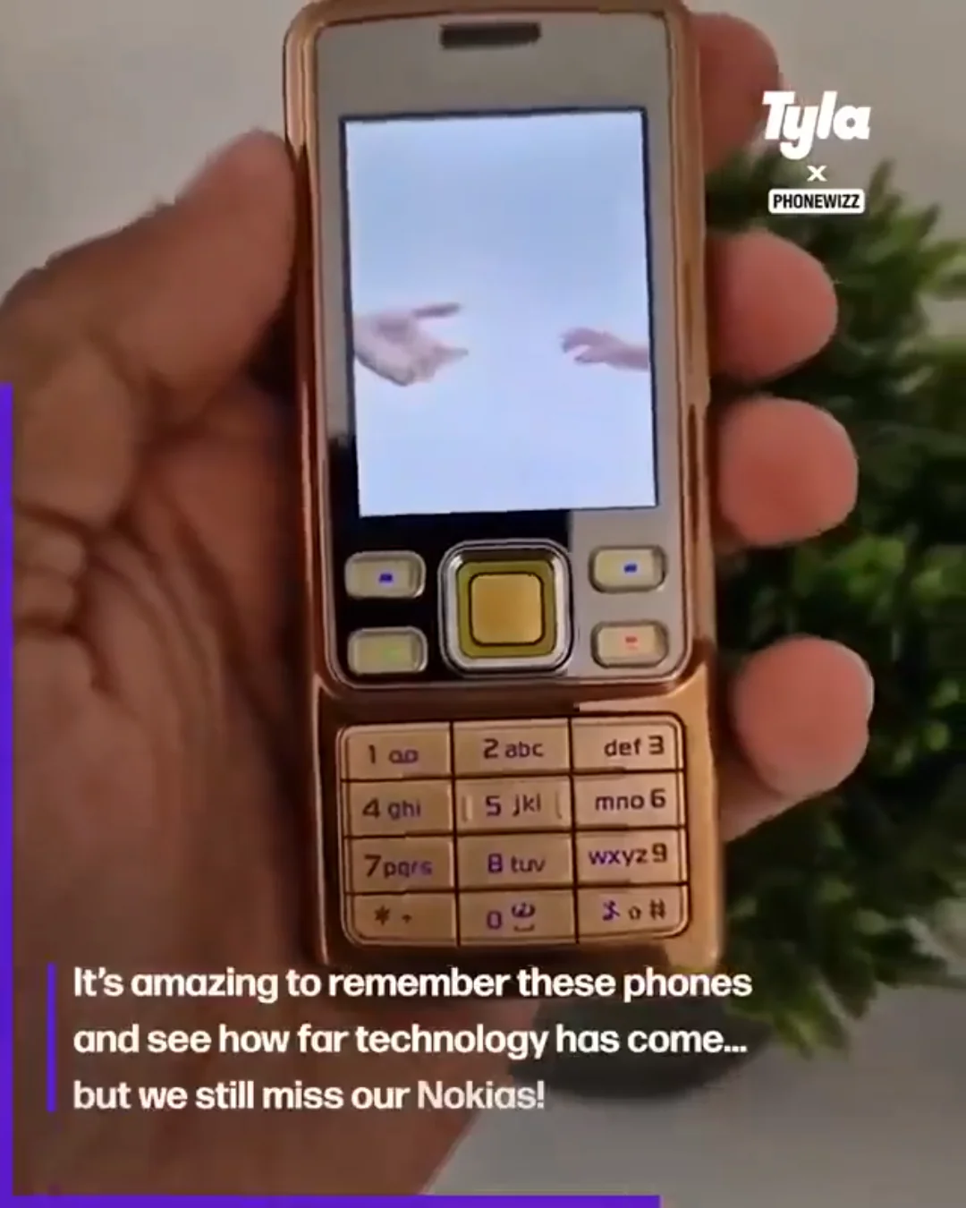A hand holds a classic Nokia-style mobile phone with a small screen showing an image of two fingers touching. Text on the image reads, “It’s amazing to remember these phones and see how far technology has come… but we still miss our Nokias!”