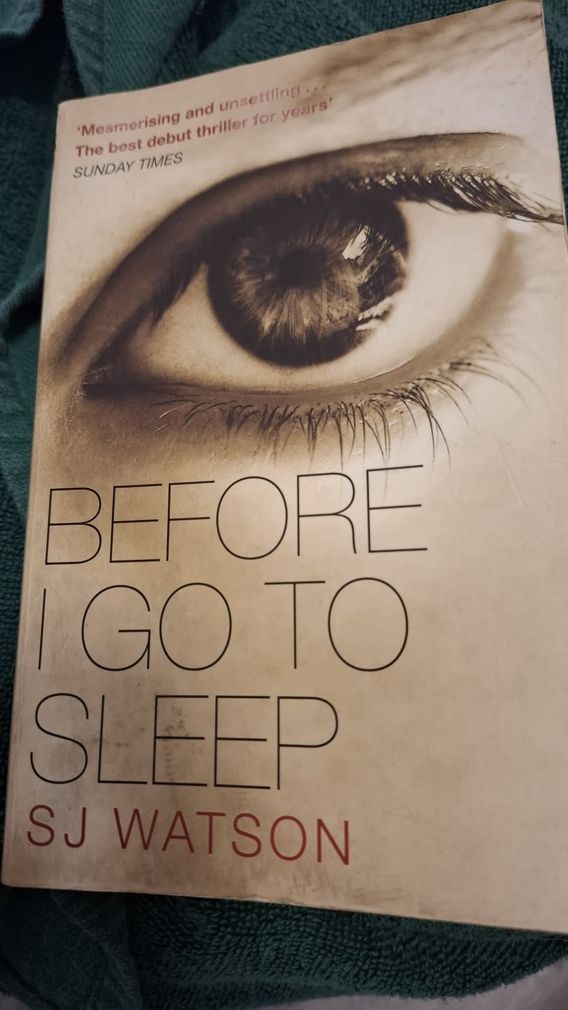 The cover of the book "Before I Go To Sleep" by SJ Watson, featuring a close-up image of a human eye above the title and author’s name. A review quote from the Sunday Times is printed at the top.