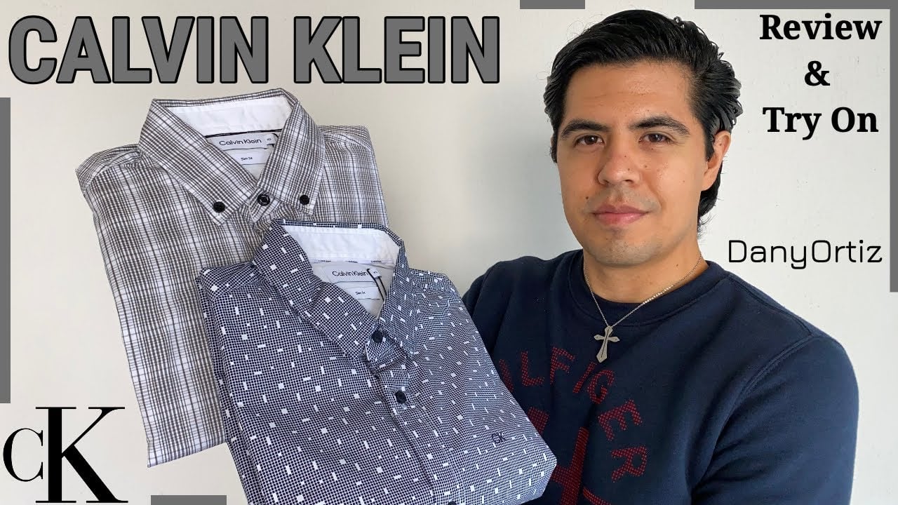 A man holding two folded Calvin Klein shirts, one gray plaid and one blue patterned. Text reads "CALVIN KLEIN," "Review & Try On," "DanyOrtiz," and "cK.