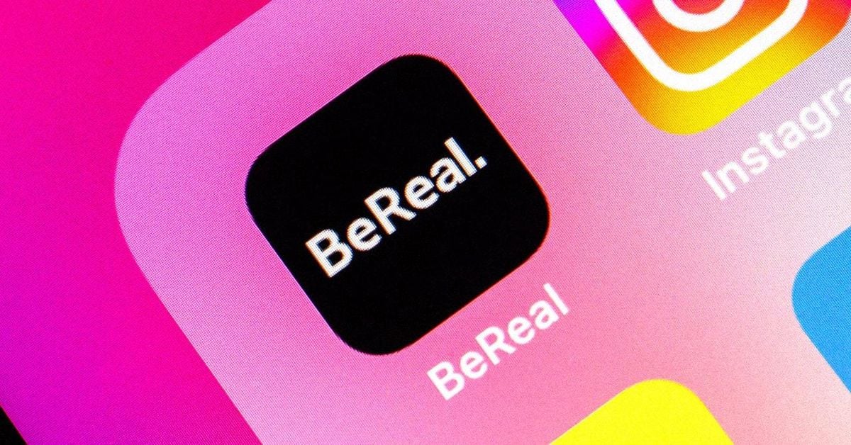 Close-up of the BeReal app icon on a smartphone screen, featuring a black square with "BeReal." in white text, next to partially visible Instagram and other app icons on a pink and orange gradient background.