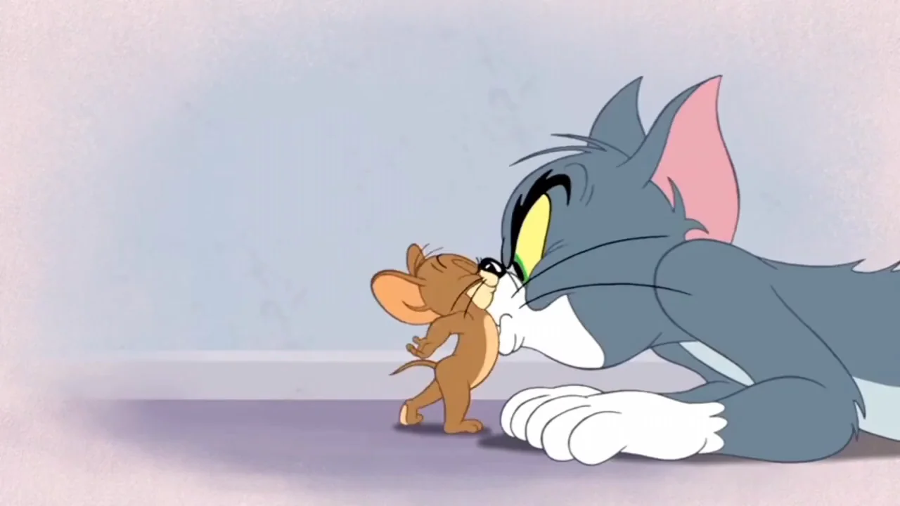 Tom the cat and Jerry the mouse stare at each other closely, face-to-face, with their noses touching in a tense and comedic moment from the animated series "Tom and Jerry.