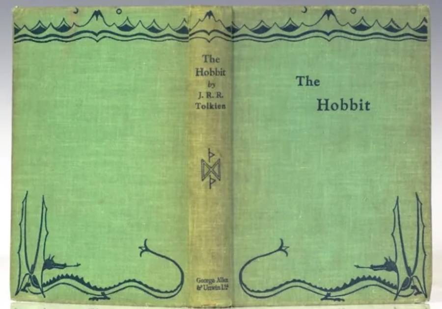 Green book cover of "The Hobbit" by J.R.R. Tolkien, featuring simple black illustrations of dragons and mountains. The title and author’s name are printed on the spine and front.